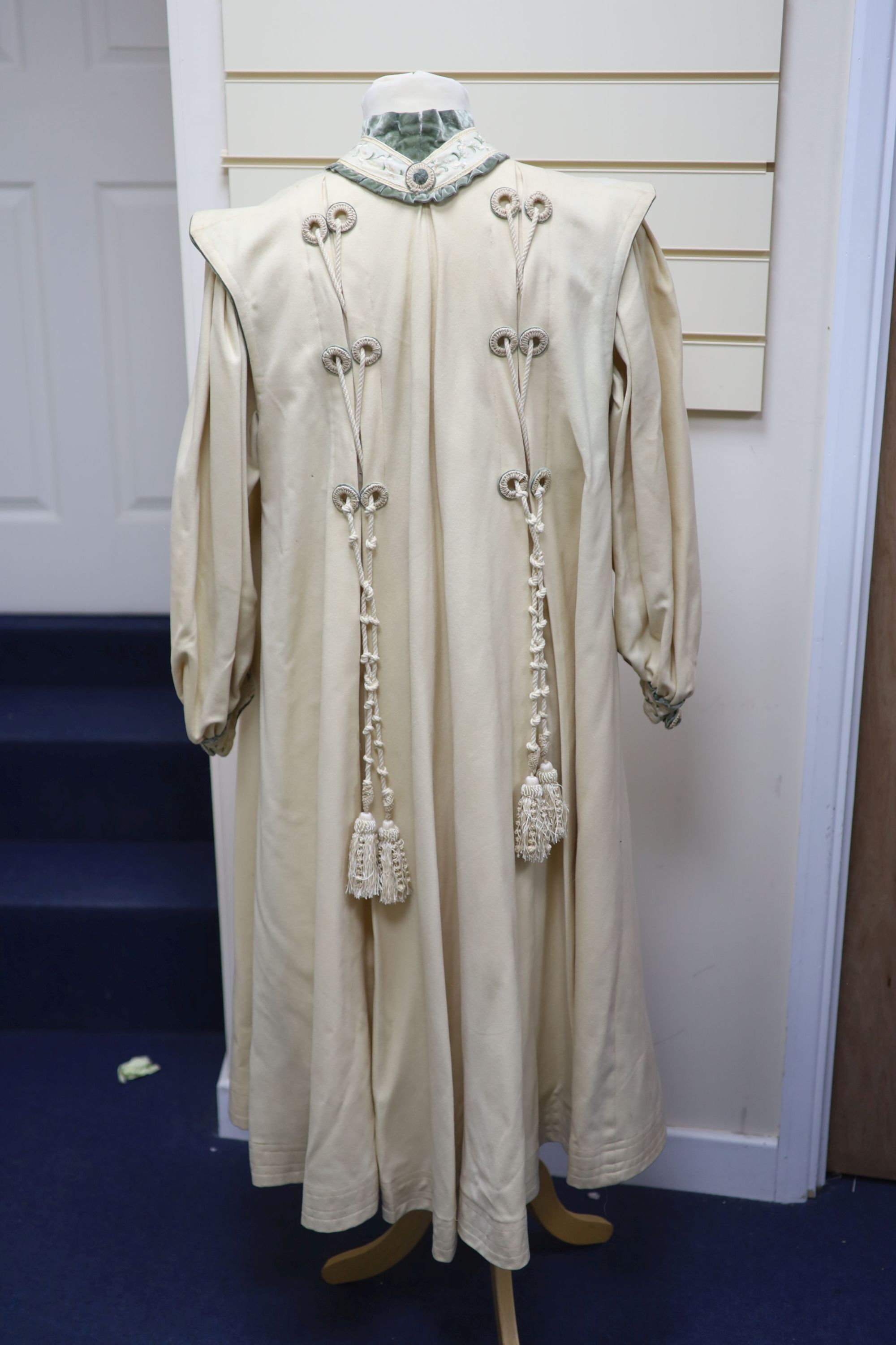 An Edwardian ladies fine cream wool coat with embroidered cuffs front edging and collar and ornate corded tasselling,